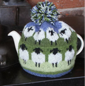 Knitted teapot cozy with sheep pattern on a stove