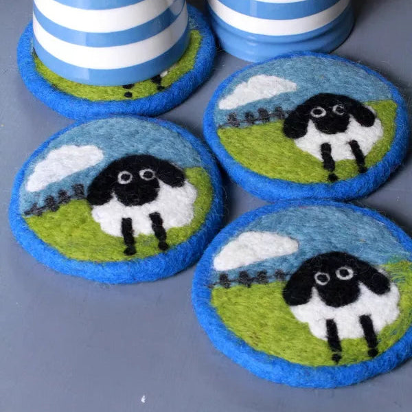 Two striped mugs with matching coasters featuring sheep designs on a gray surface.