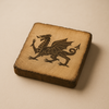 Square wooden coaster with a dragon design on a beige background