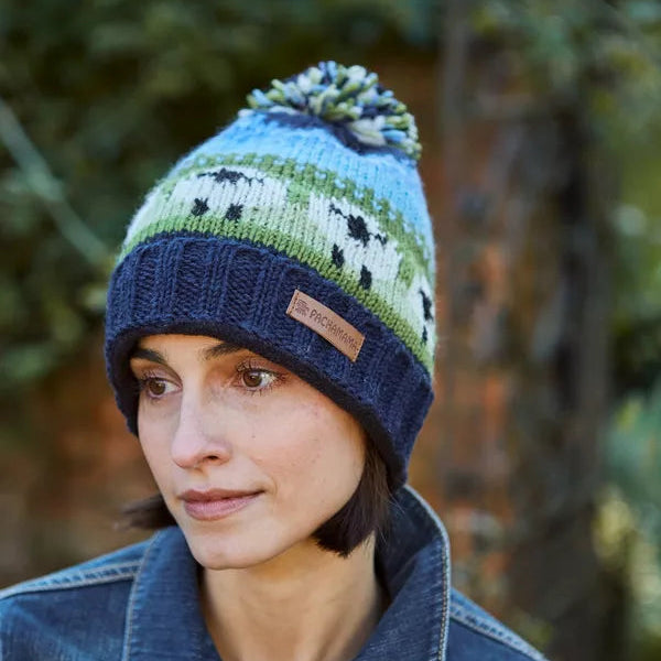 Person wearing a colorful knit beanie with a blurred natural background