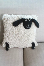 Sheep-shaped pillow on a gray couch